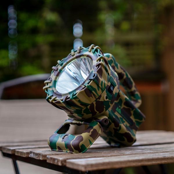 Camo spotlight grill accessory by Green Mountain Grills, designed for outdoor use, displayed on a wooden table.