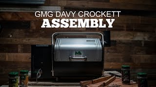 GMG Davy Crockett grill with assembly text, showcasing the product in a rustic wooden setting, highlighting features relevant to Green Mountain Grills assembly guides.