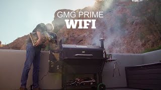 Man using Green Mountain Grills Prime with WiFi feature, surrounded by smoke, showcasing the grill's capabilities in an outdoor setting.