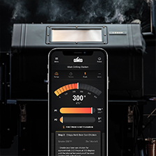Smartphone displaying grilling temperature settings in front of a Green Mountain Grill, enhancing the grilling experience.